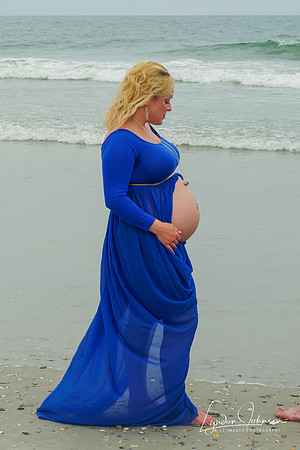 beach maternity portrait in blue dress with belly showing