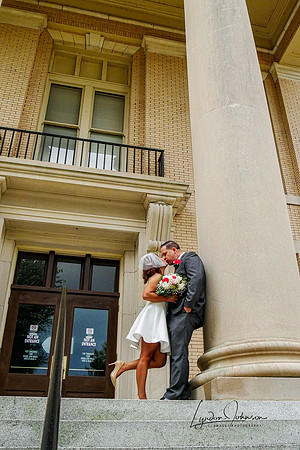 Wedding Portrait of a couple standing against columns at the Wayne county courthouse in Goldsboro NC