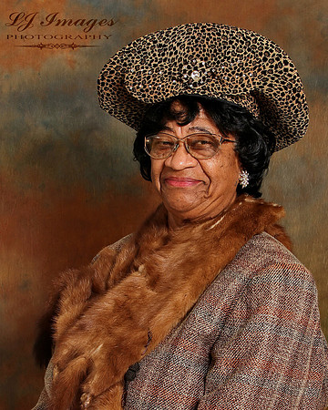 Beautiful portrait of older black woman with a fox around her neck against a brown background